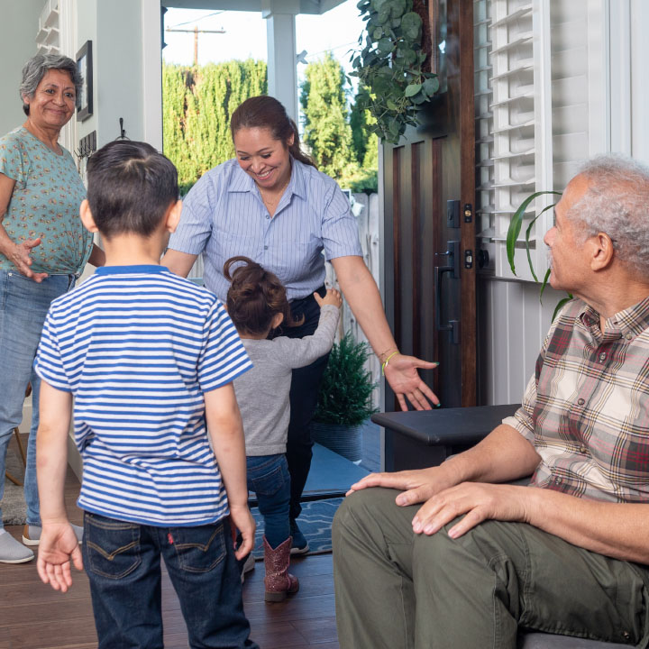 A mother being greeted by her children at the door